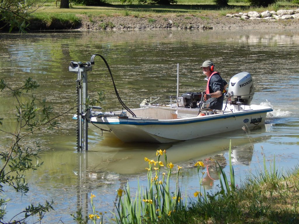 Bateau faucardeur en action sur un plan d'eau